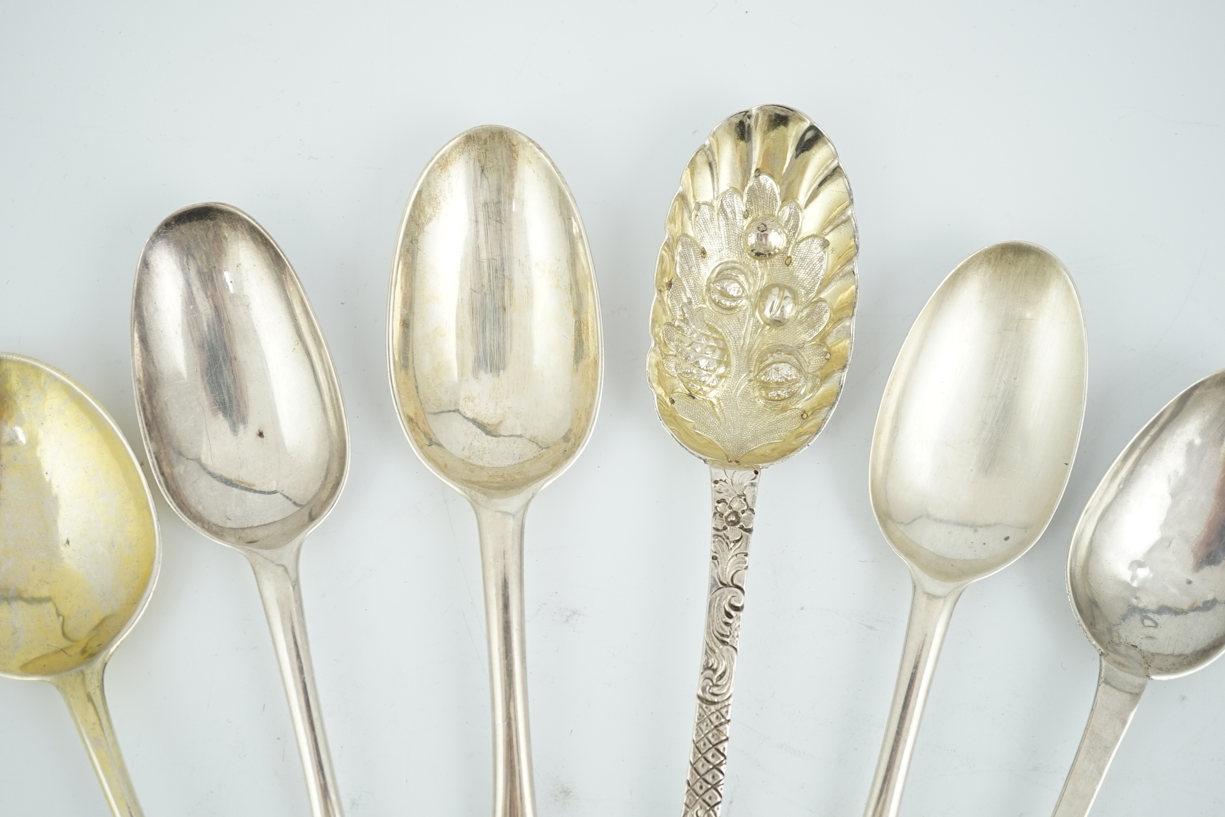 A George I provincial Brittania standard silver trefid spoon, later decorated as a berry spoon, Edmond Richard, Exeter, 1713, 21cm, together with five other 18th century spoons